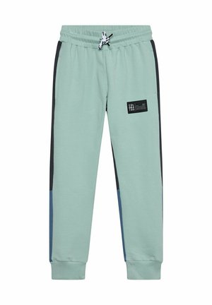 Pantaloni da jogging verde chiaro con vita elastica, strisce laterali nere, toppe blu vicino ai polsini e una piccola toppa con logo nero sulla coscia destra.