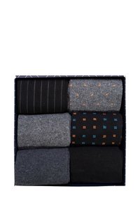 Sechs Paar Socken in einer Box. Verschiedene Texturen und Muster: Streifen, Punkte und einfarbige Designs. Farbtöne umfassen Schwarz, Grau und Akzente in Blau und Orange.