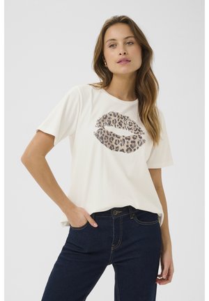 Biała bawełniana koszulka z nadrukiem w kształcie warg w leopardzi wzór. Krótkie rękawy, luźny krój, zestawiona z ciemnoniebieskimi dżinsami. Gładka tekstura.