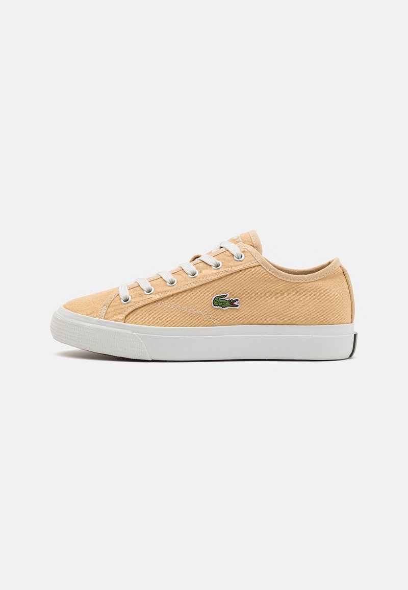 Sneakers in tela beige con suola in gomma bianca, design con lacci e logo ricamato verde. Presentano una silhouette bassa e una texture liscia.