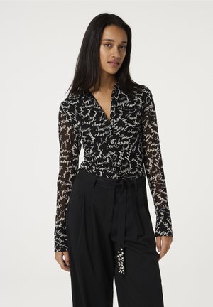 Black long-sleeve blouse with a sheer fabric and white handwritten text pattern. Features a collared neckline and curved hem.