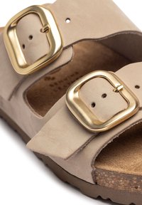 Beige suede sandal with two gold square buckles, open-toe design, cork sole, and soft texture, featuring adjustable straps for fit.