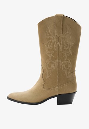 Bota vaquera de ante color canela con punta puntiaguda, costuras decorativas en un patrón en espiral y un tacón bajo y apilado.