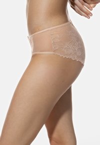 Culotte en dentelle beige avec des panneaux en filet transparent, motifs floraux et une taille mi-haute. Les bords festonnés remarquables rehaussent la texture.