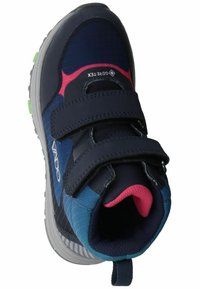 Zapatilla deportiva en azul marino y verde azulado con acentos en rosa. Cuenta con correas de Velcro, tejido texturizado y puntera redondeada. Suela gris estriada para mayor tracción.