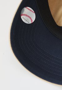 Marineblaues Baseballcap mit einer strukturierten Krone und einem hellbraunen Untervisor. Verfügt über ein rundes Etikett mit einer Baseballgrafik und Text.