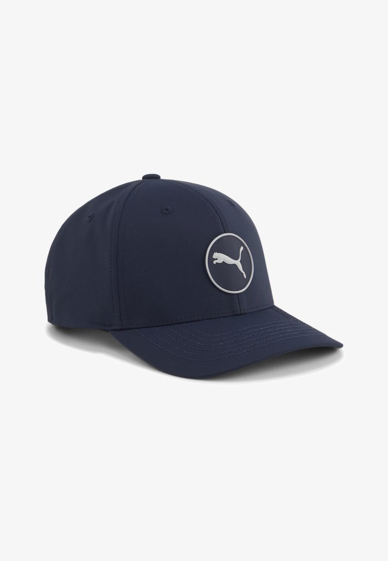Gorra de béisbol azul marino con visera curva y parche redondo del logo de Puma en el panel frontal, con detalles de costura visibles en la visera.