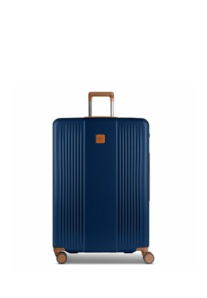 Gran maleta rígida azul marino con detalles marrones, asa extensible y cuatro ruedas giratorias para una fácil movilidad.
