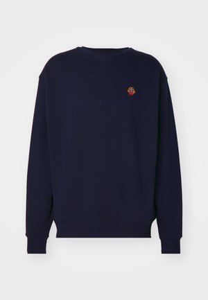Sweat-shirt bleu marine avec un col rond, des manches longues et des poignets côtelés. Présente un petit motif brodé sur la poitrine.