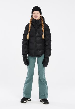 Doudoune noire à motif pied-de-poule, associée à un pantalon de neige teal et des gants noirs. Un bonnet chaud complète la tenue d'hiver.