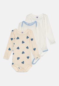 Tre body a manica lunga: uno beige con motivi a cuore blu, uno bianco solido e uno bianco solido con dettagli a righe blu nel colletto.