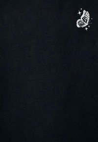 Black T-shirt made of soft fabric featuring a small, white butterfly graphic with sparkles in the upper left corner.