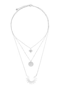 Collana a strati in argento con tre catene. La catena superiore sostiene un pendente a stella, quella centrale un cerchio testurizzato e quella inferiore un design a raggi di sole.