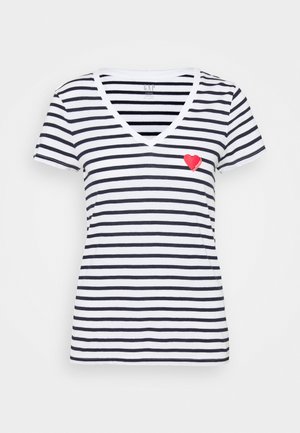 Wit V-hals T-shirt met zwarte horizontale strepen en een kleine rode hartafbeelding op het linkerbovenborstgebied.