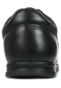 Scarpa da ginnastica nera con tomaia in pelle liscia, tacco arrotondato, suola imbottita e cuciture minime per un design elegante.