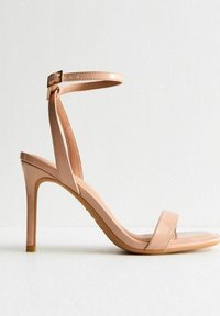 Naakt hoge hak sandaletten met een glanzende afwerking, open teen, dunne enkeltas en een vierkante teen ontwerp, met een sleek, minimalistische stijl.