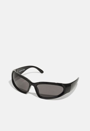 Czarne okulary przeciwsłoneczne o smukłym, zespolonym designie, z ciemno przyciemnionymi soczewkami i błyszczącymi plastikowymi oprawkami. Na ramieniu widnieje nazwa marki.