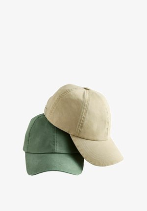 Twee effen katoenen honkbalpetten opgestapeld, een beige bovenop en een groene eronder, geïsoleerd op een witte achtergrond.