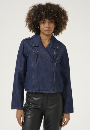 Marineblauwe denim cropped jack met een reverskraag, asymmetrische rits en drukknoopdetails. Gestyled met lange mouwen en een getailleerd ontwerp.