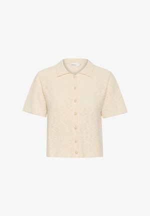 Rövid ujjú gombos ing krém színben, textúrált anyagból, puha felülettel. Gallérral és gyöngyszerű gombzárakkal rendelkezik.