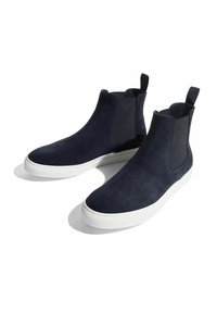 Marineblaue Wildleder-Ankle-Boots mit elastischen Seiteneinsätzen und weißen Gummisohlen. Sie verfügen über ein minimalistisches Design und Ziehhilfen für ein leichtes Anziehen.