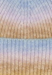 Knitted beanie in gradient shades of blue, beige, and soft brown. Features textured ribbing and a snug fit.