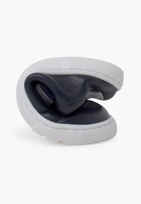 Navy leather shoe with a white rubber sole, featuring a rounded design and a flexible structure, showcasing smooth texture and minimal stitching.