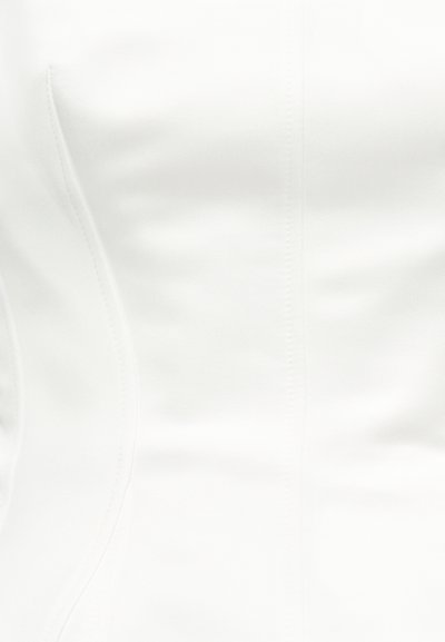 Gros plan sur un tissu en cuir blanc avec des détails de couture verticale visibles et une texture subtile.