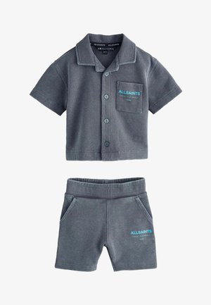 Ensemble composé d'une chemise à manches courtes à boutons avec texture gaufrée grise et d'un short assorti, avec des logos bleus "ALLSAINTS" sur la poche poitrine et la jambe gauche du short.