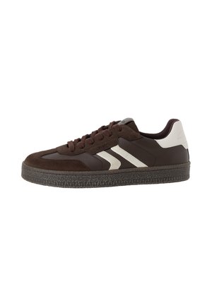 Lavtopet sneaker i mørkebrun ruskind og læder med hvide hæl- og sidestriber, tekstureret mørk sål og snørelukning.