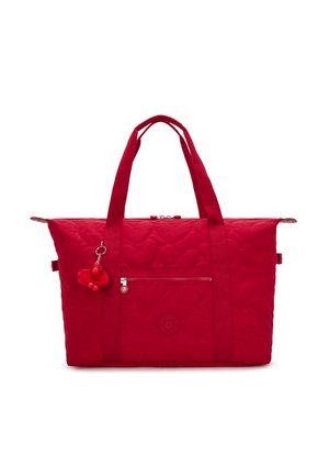 Bolso tote acolchado rojo con asas dobles, bolsillo frontal con cremallera y un pequeño llavero de mono de peluche colgado de una de las asas.