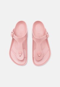 Ροζ λαστιχένιες σαγιονάρες με ρυθμιζόμενους ιμάντες και στρογγυλεμένη περιοχή δαχτύλων, απεικονισμένες από ψηλά σε λευκό φόντο.