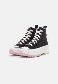 Höga sneakers med svart texturerad ovandel, vit gummitåhuvud och rosa genomskinlig sula. Har rosa och vita snören.