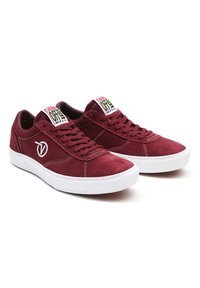 Baskets en daim bordeaux avec semelles en caoutchouc blanches, dotées de lacets plats et d'accents du logo Vans sur la languette et le côté.