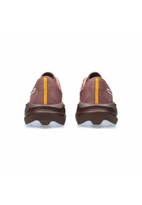Scarpe da ginnastica color marrone ramato con tomaia in rete testurizzata, dotate di una striscia verticale gialla, suola marrone e dettagli azzurri chiari sulla suola esterna.
