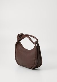 Borsa in pelle marrone con manico annodato, forma arrotondata e chiusura a zip. Texture liscia con dettagli di cucitura discreti.