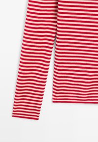 Langsleeve kledingstuk met rood en witte horizontale strepen op een plain witte achtergrond, dat een deel van het lichaam en één arm toont.