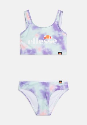 Zestaw kąpielowy składający się z krótkiego topu i dołu bikini, w wzór tie-dye w pastelowym fioletowym i miętowym kolorze, z białym logo i czarnymi akcentami.