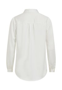 Camicia bianca a maniche lunghe con colletto classico, dettaglio con piega sul retro e polsini abbottonati. Tessuto liscio con una leggera lucentezza e orlo arrotondato.