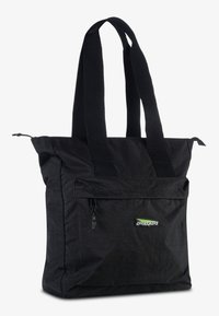 Černá taška přes rameno s širokými textilními ušima, přední kapsa na zip a malé zelenobílé logo na kapse.