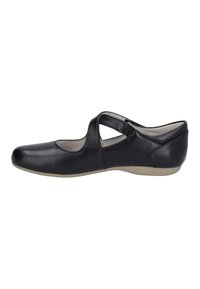 Zapato de cuero negro con puntera redondeada, diseño de tiras cruzadas, tacón bajo y una textura suave. Presenta una suela en color neutro tostado.