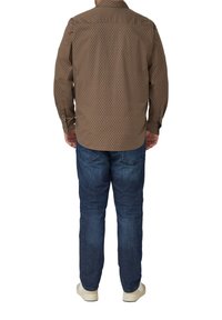Brown patterned long-sleeve shirt with a button-down collar, paired with blue jeans and light-colored shoes, viewed from the back.