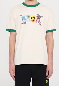 Beige t-shirt with green ribbed collar, featuring colorful cartoon bears and graphics. Short sleeves, relaxed fit, soft cotton material.