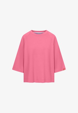 Rosa Langarmshirt mit Rundhalsausschnitt, weiten Ärmeln und dezentem "FRIEDA"-Schriftzug auf der Brust sowie einem kleinen orangenen Etikett am linken Ärmel.