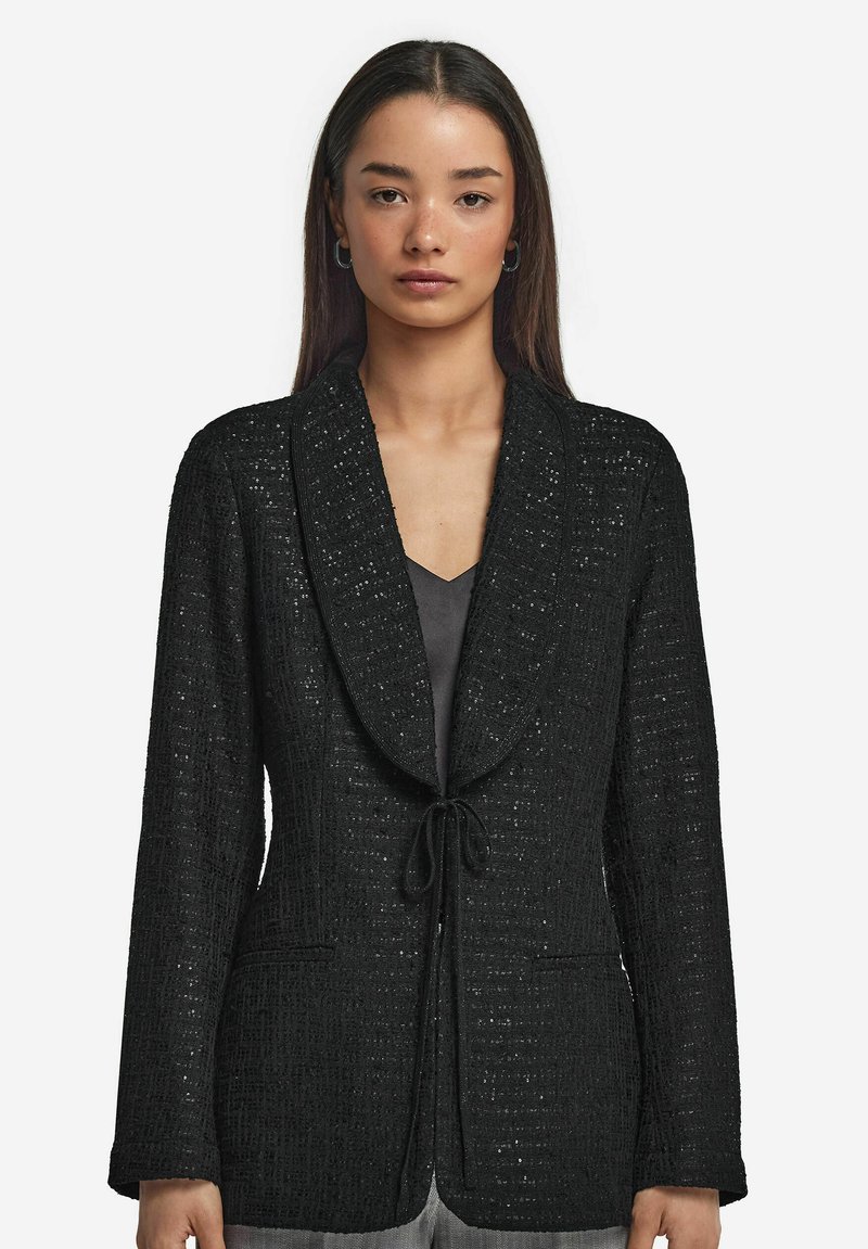 Svart texturerad kavaj med knytstängning, notch-lapel och två framfickor. Tyget har ett subtilt mönster och en strukturerad passform.