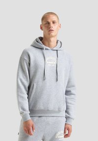 Felpa grigia in cotone con tasca a marsupio, cappuccio con cordino e logo stampato in beige, con polsini e orlo a costine.