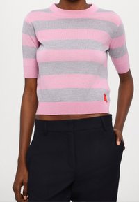 Maglione a maniche corte a righe in rosa e grigio, realizzato in morbido tessuto a maglia. Design cropped con scollatura e orlo a coste.