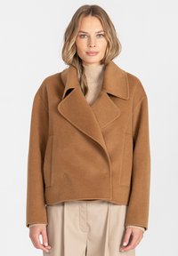 Przycięty, dwurzędowy płaszcz z jasnobrązowej mieszanki wełny, z dużymi klapami z wycięciem, bocznymi kieszeniami i luźnym krojem.