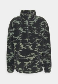 Fleece-Pullover in Schwarz und grünem Camouflage-Muster, mit halbhohem Reißverschluss, Seitentaschen und einer weich strukturierten Oberfläche.