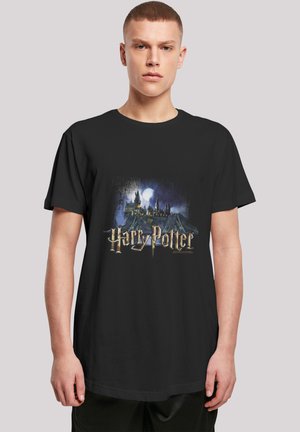 Black cotton t-shirt featuring a graphic of Hogwarts with a moon, and the text "Harry Potter" in metallic gold font. Short sleeves, relaxed fit.